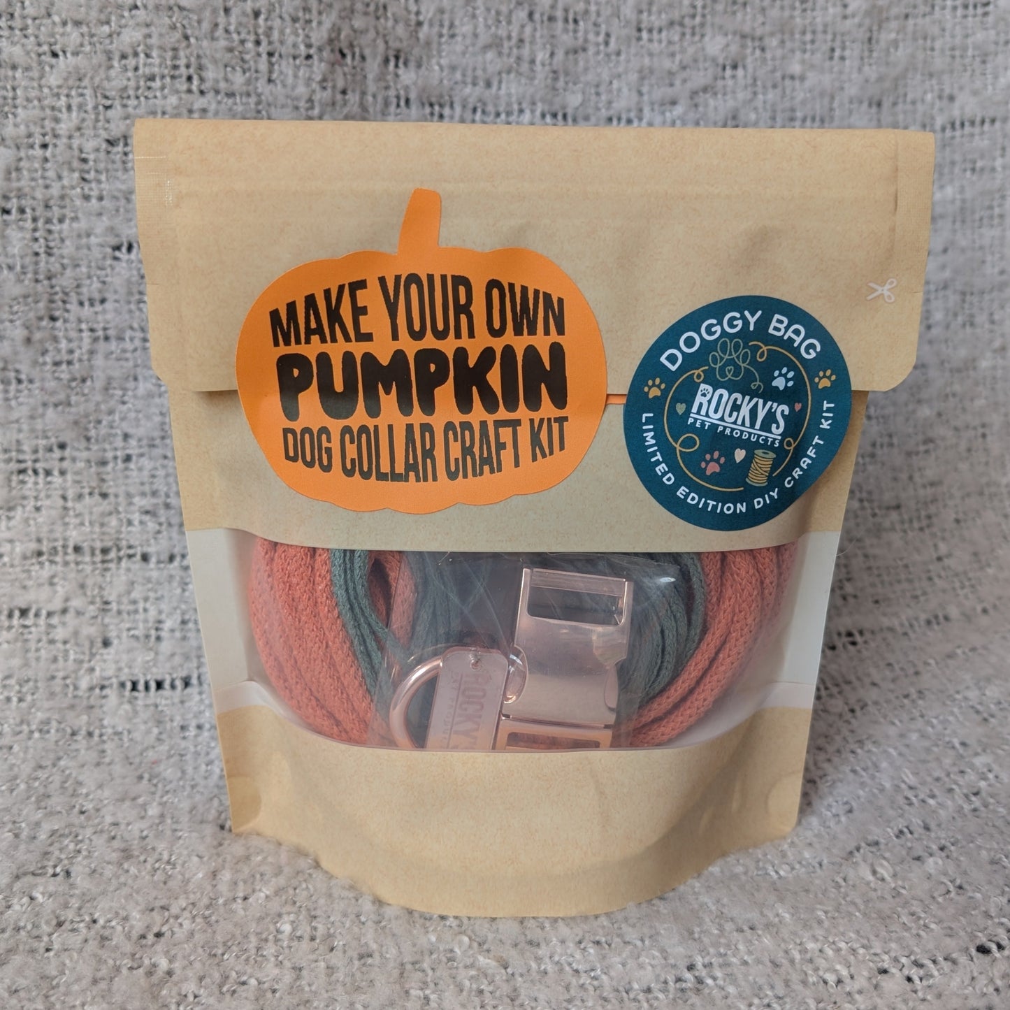 Dog collar craft kit packaging with 'Make Your Own Pumpkin' text on a textured gray background