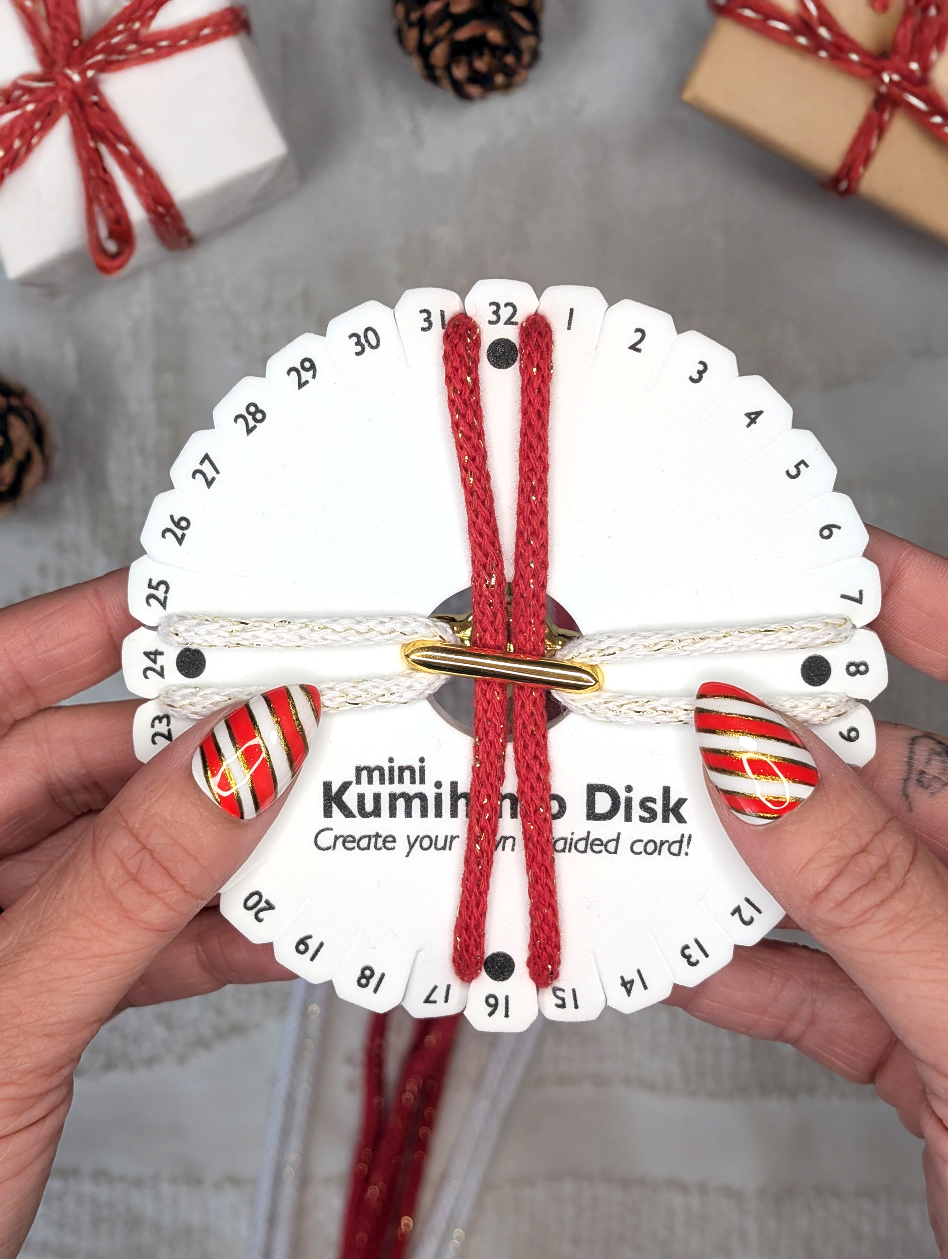kumihimo braiding disk with red and white sparkle 5mm macrame cord, kumihimo braiding disk and christmas presents in background